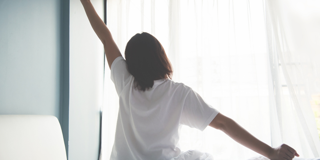 woman stretching as she performs her morning routine