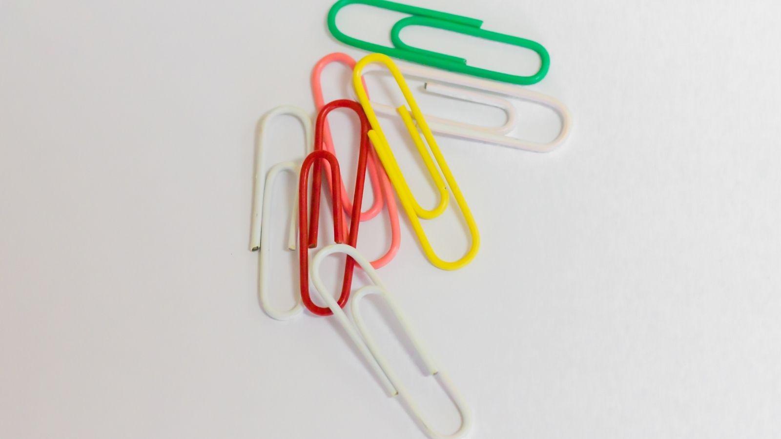 image shows 6 colourful paperclips in a messy heap on a white background