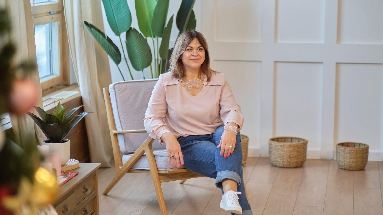 image of a perimenopausal woman sitting on a chair surrounded by plants