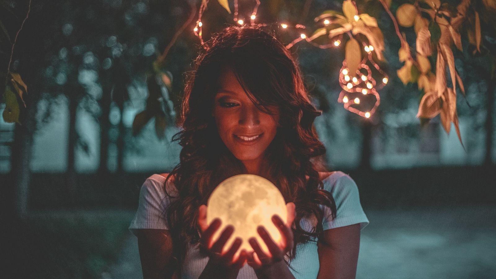 Give yourself permission. Image of woman holding moon in hands.