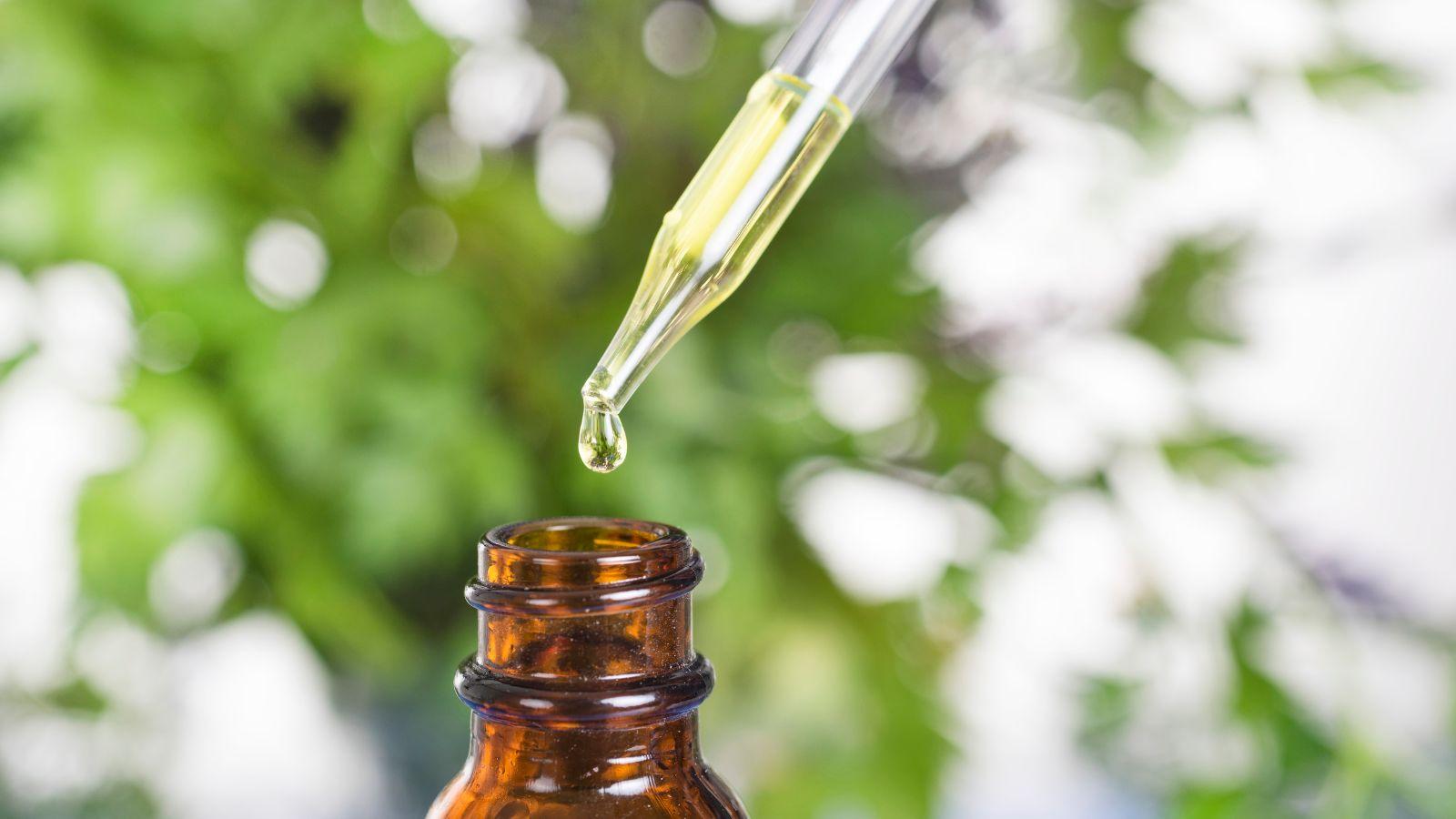 essential oils to aid sleep vetiver. Image of a dropper bottle and vial of essential oil on a plant based background