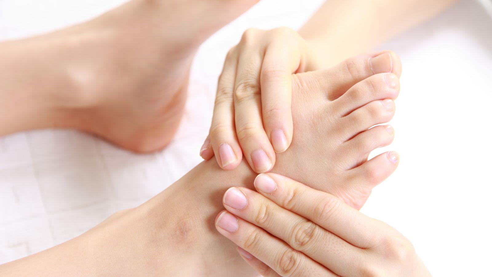 massage, reflexology or reiki which treatment should I pick? image of a pair of hands giving reflexology.