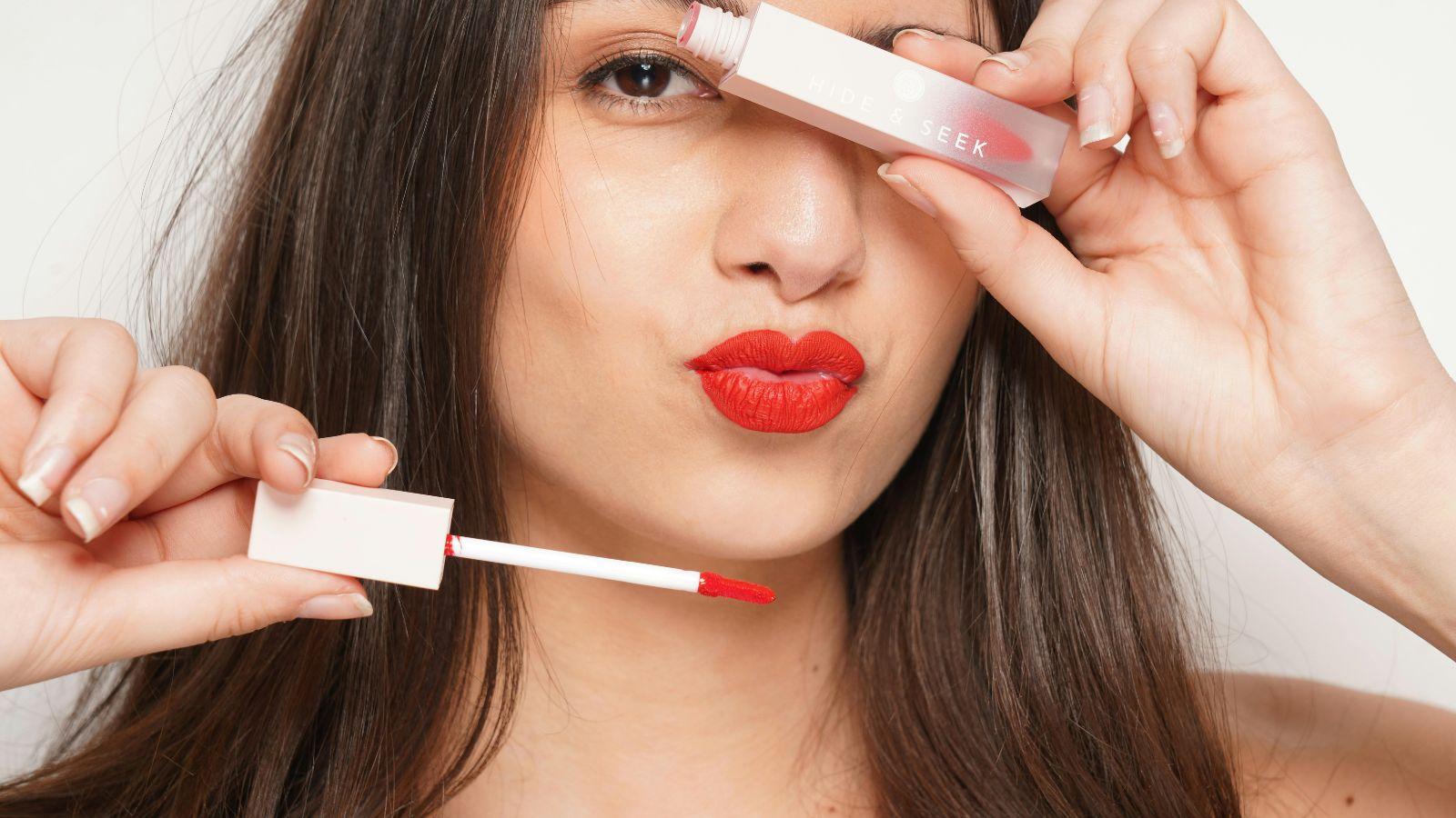 image of woman holding a lipgloss to illustrate being a goddess