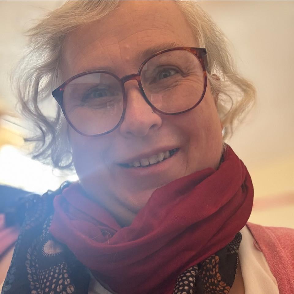 Image of Sarah Cooper Reflexology and Massage  she has big red glasses and a smile and has a burgundy scarf 