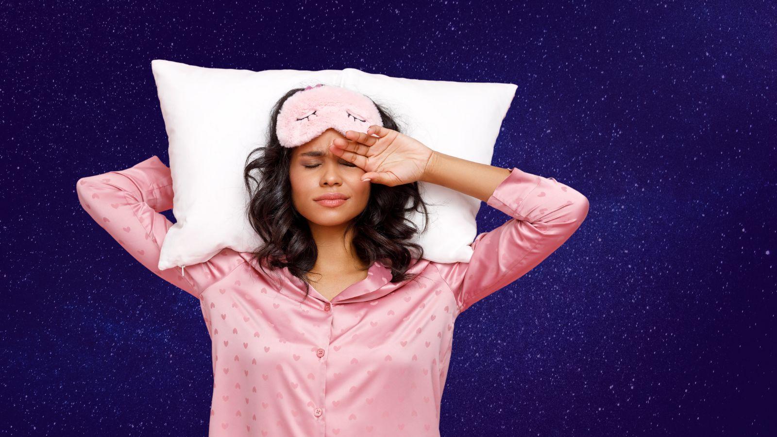 vetiver essential oil helps with sleep image of a woman in pink pjs on a sky background with a sleep mask