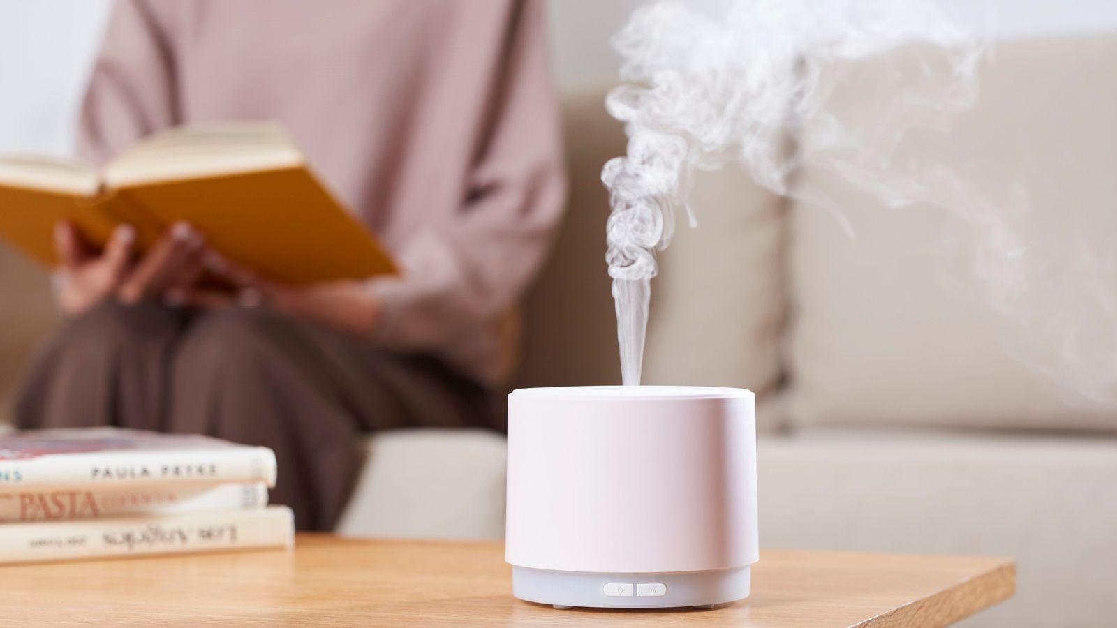 vetiver essential oil works well in a diffuser image of woman with a book and a diffuser