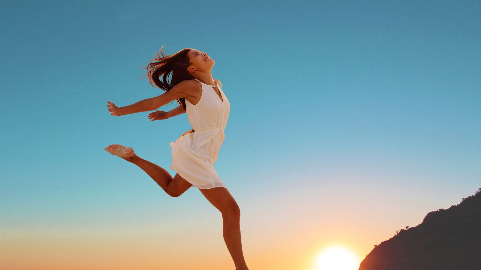 What if everything works out ok? Image of woman running across a sunset in a short creamy dress