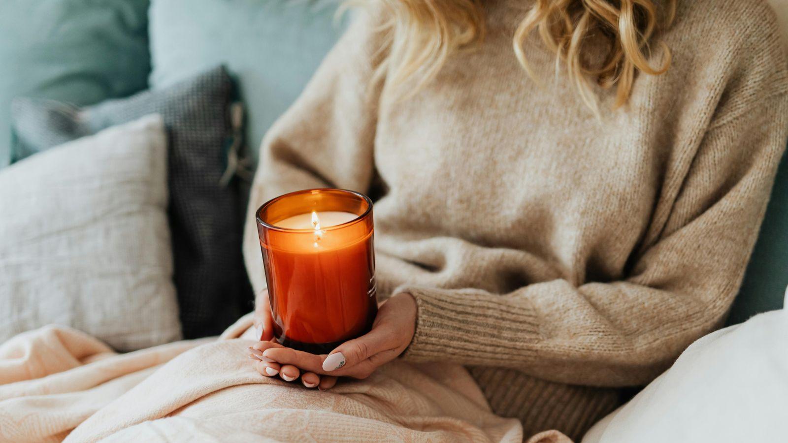 quick and easy ways to raise your home’s vibration quick and easy ways to raise your home's vibration. Image of a woman holding an orange candle